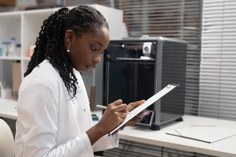Female 3D Printer Engineer Writing on Clipboard Foto stock