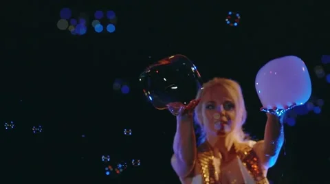 Female actor binds multiple gas bubbles. Bubble show. Stock Footage 67585603