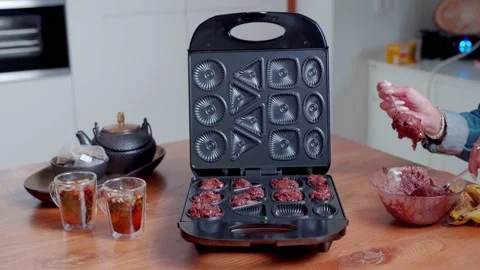 Female adding cookie dough onto cookie maker machine with different shapes Stock Footage 237986146