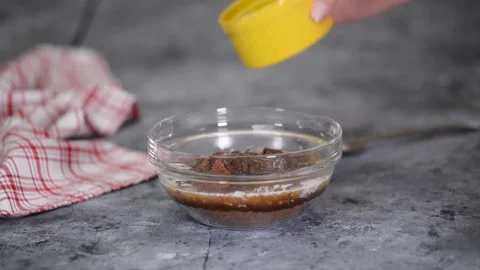 Female Adding Melted Butter To Crushed Biscuits to Make Pastry Crust for Stock Footage 146036652