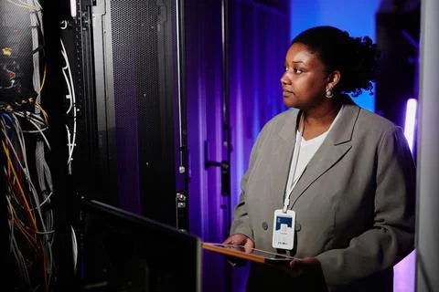 Female Admin using Laptop in Server Room Foto stock
