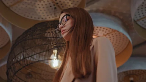 Female admiring ceiling design. Reflective woman in beige blazer inspecting Stock Footage 341665200