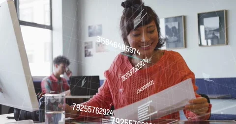 Female analyst scrolling mouse at desk, sorting holographic numeric data for Stock Footage 318515936