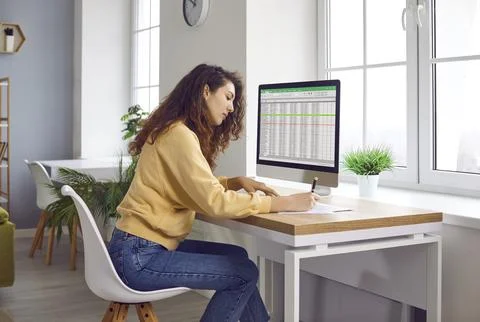 Female analyst working with spreadsheet data on computer screen Stock Photos