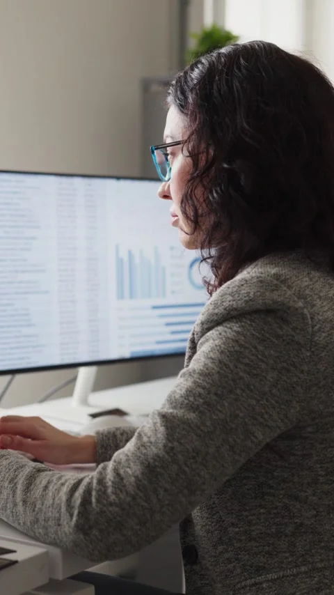 Female analyst working on spreadsheets on three monitors in office, accounting Stock Footage 341009787
