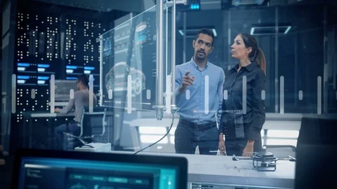 Female and Male Engineers Analyzing Data on Futuristic Transparent Touch Screen. Stock Footage