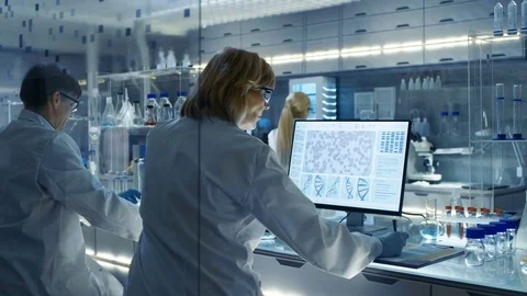 Female and Male Scientists Working on their Computers In Big Modern Laboratory.  Stock Footage