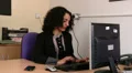 Female answers her mobile phone at work HD Footage