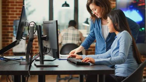 Female app developers working on software production with multiple displays Foto stock