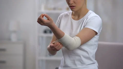 Female applying elbow elastic warp after sport trauma orthopedics and healthcare Stock Footage 108501963