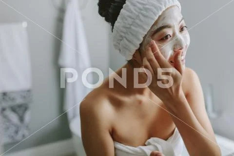 Female in applying facepack in bathroom Stock Photos
