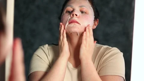 Female applying moisturizing face mask in bathroom. Beauty routine Stock Footage 312011822