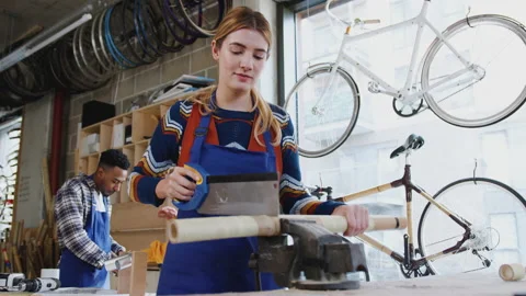 Female Apprentice In Carpentry Workshop For Building Bicycles Frame Sawing Wood Vídeos de archivo 130427090