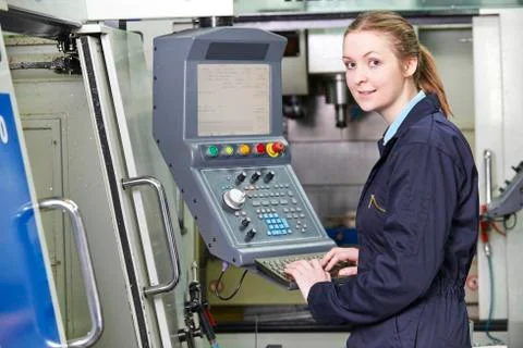 Female Apprentice Engineer Operating Computerized Cutting Machine Stock Photos