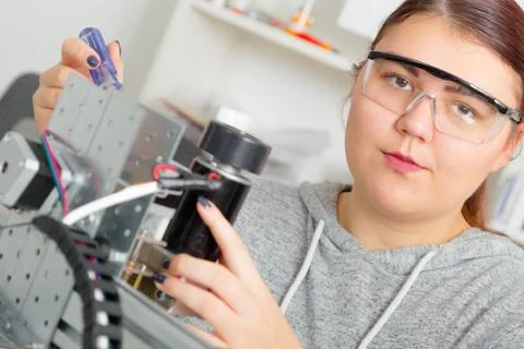 Female Apprentice working  on CNC machinery. Stock Photos