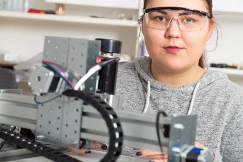 Female Apprentice working  on CNC machinery. Stock Photos