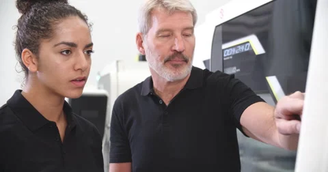 Female Apprentice Working With Engineer On CNC Machinery Video stock 56213572
