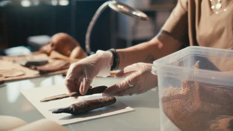 Female Archaeologist in Gloves Analyzing Ancient Tools in Laboratory Stock Footage 296514671