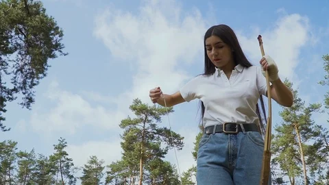 Female archer pulling the string on her bow Video stock 96760538