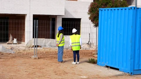 Female architect and engineer discussing building plans on a construction site Stock Footage 334553905