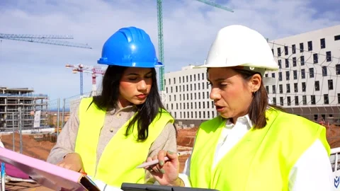 Female architect and engineer discussing project at construction site Stock Footage 334578217