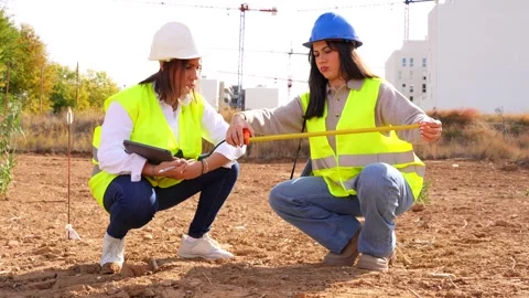 Female architect and engineer measuring land on a construction site Stock Footage 334554314