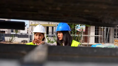 Female architect and engineer reviewing plans on a construction site Stock Footage 334554133