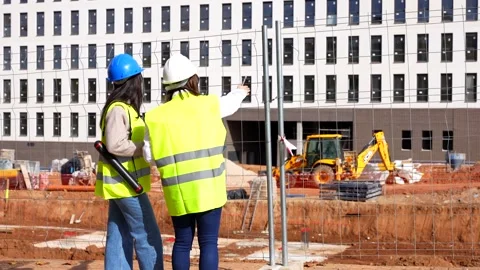 Female architect and engineer reviewing construction site plans Stock Footage 334582937