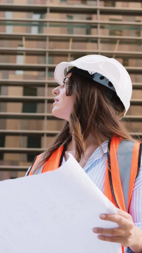 Female architect checking blueprints at construction site Stock Footage 343429012