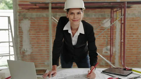 Female architect checking blueprints inside a building at a construction site Stock Footage 228673408