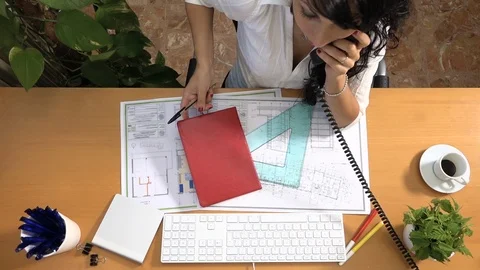 Female architect on desk drawing plan and having breakfast in the studio Stock Footage 88446947