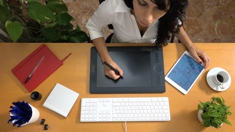 Female architect drawing building plan with graphic tablet talking on phone Vídeo Stock 88530728