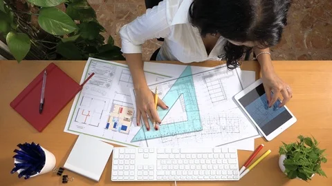 Female architect drawing building plan with graphic tablet correcting measures Stock Footage 88541678