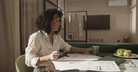 Female architect drinking coffee and working on project Stock Footage 207668666