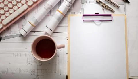Female architect engineer office desk. Blueprint plans,  blank notepad and a Stock Photos