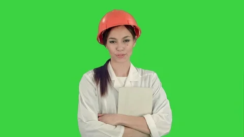 Female architect in hardhat holding tablet talking to camera on a Green Screen Stock Footage 71754913