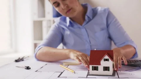 Female architect with house model and blueprint Stock Footage