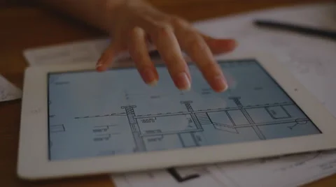 Female Architect Studying Plans In Office at desk with plans Stock Footage