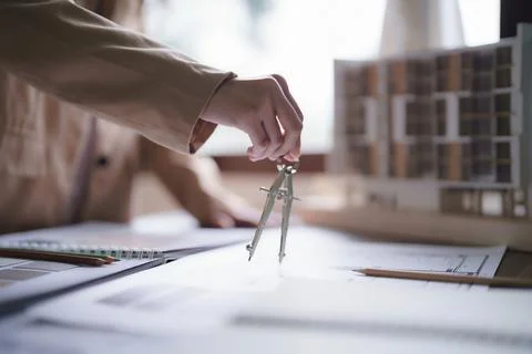 Female architect using divider compass to drawing building project and desi.. Fotos de archivo