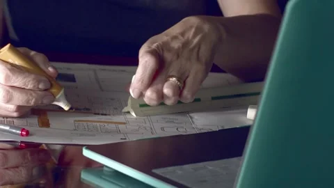 Female architect using a yellow highlighter to mark up blueprints Stock Footage 226295230