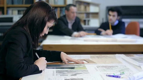 Female architect working with colleagues in background Stock Footage 49784136