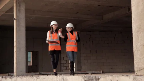 Female architects at a construction site, depending on how the construction Stock Footage 97808312