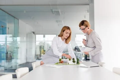 Female architects discussing model in conference room meeting Stock Photos