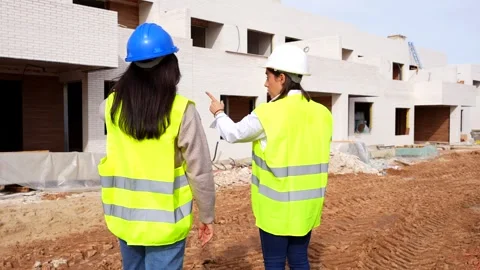 Female architects discussing project at building construction site Stock Footage 334554672