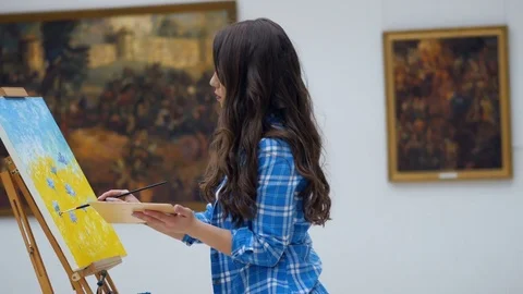 Female artist painting a picture on canvas. Art gallery background. 4K. Stock Footage
