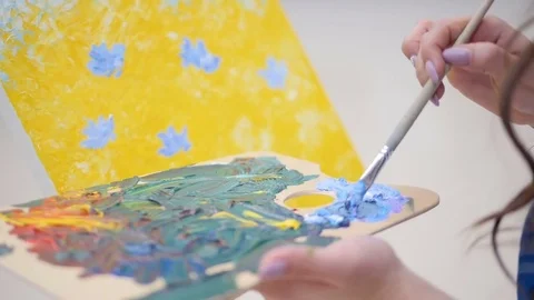 Female artist is preparing right shade of blue. Stock Footage