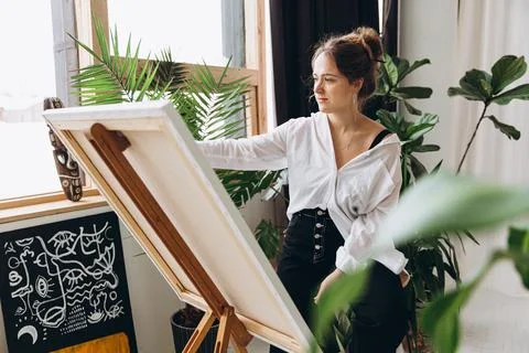 Female artist using brush and color palette for painting Stock Photos