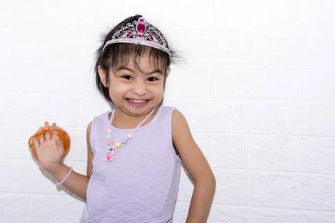 Female asian child girl posing wacky while wearing some accessories like crow Stock Photos