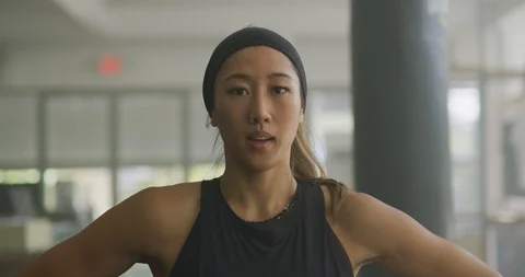 Female athlete breathing deeply while looking at the camera Stock Footage 99320332