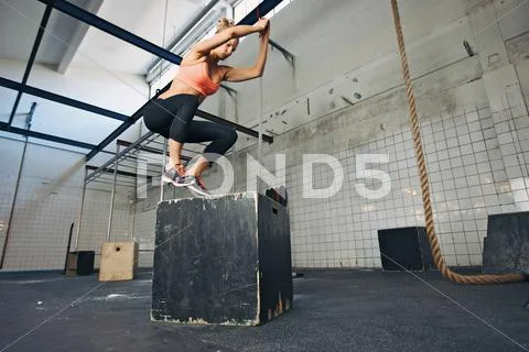 Female athlete is performing box jumps at gym Stock Photos